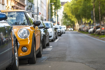 Naklejka premium Rzędy samochodów zaparkowanych na poboczu drogi w dzielnicy mieszkalnej