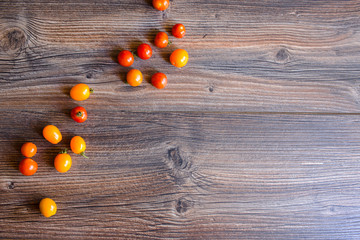 A lot of red and yellow mini tomatoes on the table. Background.
