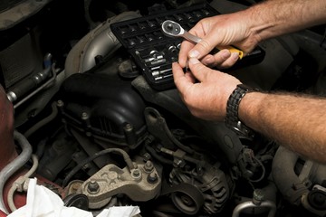 The mechanic fixes the vehicle's engine