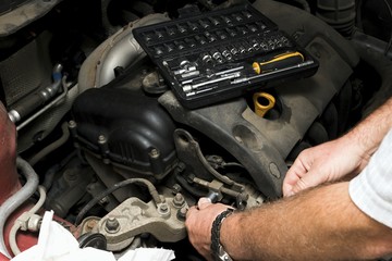The mechanic fixes the vehicle's engine