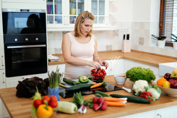 Pregnant woman making a meal in kitchen