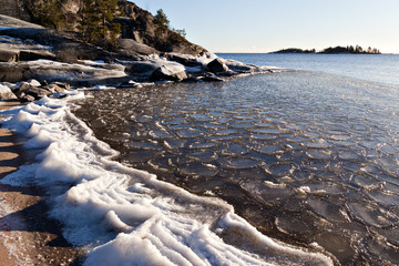 Freezing water on a sandy beach on Lake Ladoga