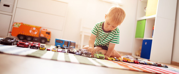 Little child playing with toy cars