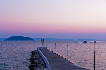 Pier at twilight with turtle island in a background, near the city of Neos Marmaros in Sithonia, Greece