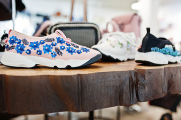 Huge variety of female shoes and bags of different colors on the shelves of the shop.