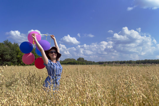 Young Woman With Balloons In Oat Field