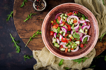 Tomato, cucumber and red onion salad with black pepper and arugula