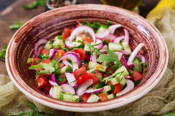 Tomato, cucumber and red onion salad with black pepper and arugula