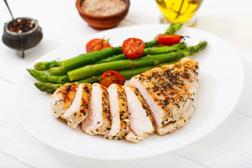 Chicken fillet cooked on a grill and garnish of asparagus