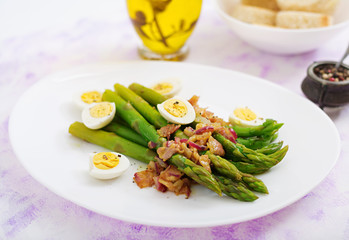 Young shoots of asparagus with ham and quail eggs