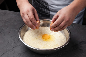 the cook breaks the egg into dough, for cooking potato pancakes