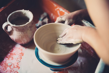 Work in a pottery workshop, womans hands creating ceramics. 