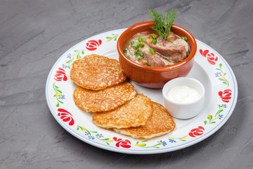 traditional Belarusian dish, potato pancakes with baby meat, black stone structure background