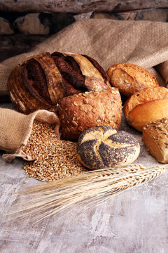 Different kinds of bread and bread rolls on board. Kitchen or ba