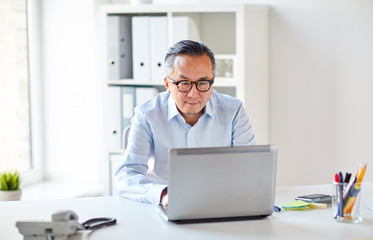 businessman in eyeglasses with laptop office