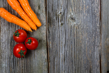 Fresh raw carrot and potatoes in an old sack on wooden background. Free place for text. Top view