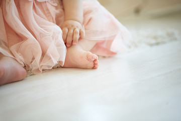 Obraz na płótnie Canvas little baby on the floor with drawn smiley face on her big toe