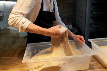baker making bread dough at bakery kitchen