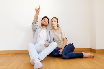 happy couple at empty room of new home