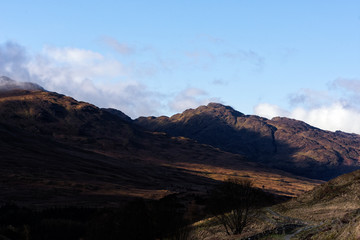 Fototapeta premium the morning sun creeping over the mountains along the West Highland Way