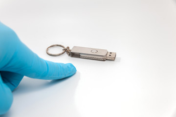 hand in blue glove holding flash drive