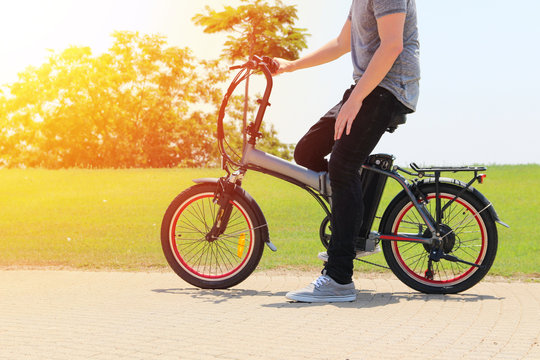A man with  electric bicycle in a park