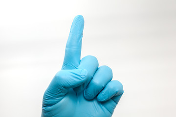 hand in blue glove showing number one sign