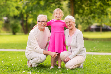 senior grandparents and granddaughter at park