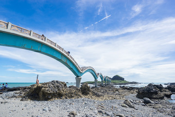 Fototapeta premium Panoramic view of Sansiantai bridge with beautiful sea level and reef rocks under fantasy blue cloudy and sunshine sky in Sansiantai Taitung. the famous attractions in Taiwan.