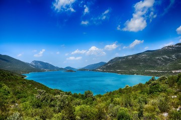 Fototapeta na wymiar view on cristal clear blue water lake mountains around 