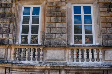 twin old window on stone wall 