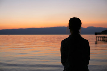 Silhouette of young woman on beach sunset.