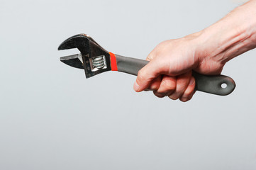 Wrench with hand on white background