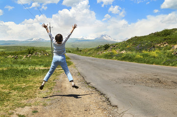 Woman tourist jumping enjoying beautiful mountain view in Armenia  