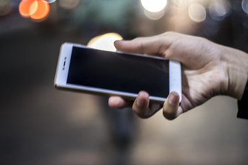 Mobile phone in hand, night, city ??of Light background, sms, message, e-mail