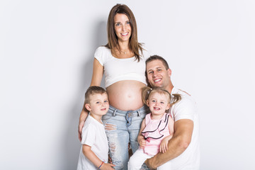Happy family with two kids on studio gray background