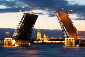 Fototapeta na wymiar Divorced Palace Bridge and Peter and Paul Cathedral on a cloudy June night. St. Petersburg