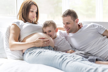 Obraz premium father, son and pregnant mother at home. Beautiful loving family portrait