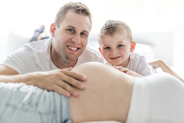 Fototapeta premium father, son and pregnant mother at home. Beautiful loving family portrait