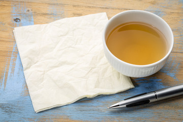 cup of tea with napkin and pen