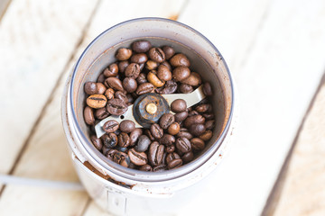 Fried coffee beans in a coffee grinder. Macro 
