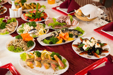 Close up of severed table with different food and dish, meat, fruits, fish in restaurant. Taste evening for big company. 
