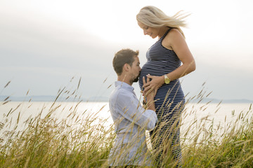 pregnant woman at beach with husband having fun