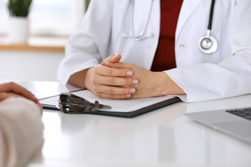 Close up of a doctor and patient hands while discussing medical records after health  examination