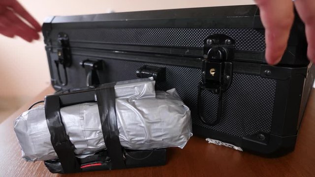 A man puts a homemade explosive device in his suitcase. Preparation of terrorist act. 4k. Slow motion