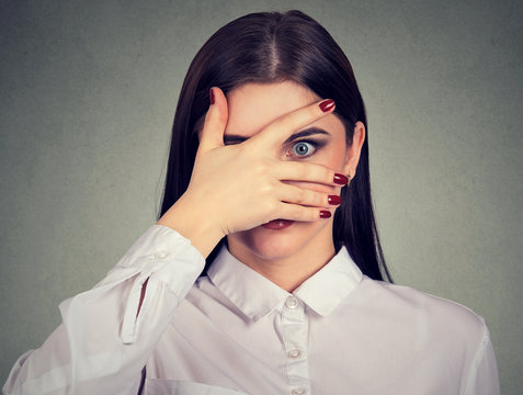 Scared Young Woman Peeking Through Her Fingers