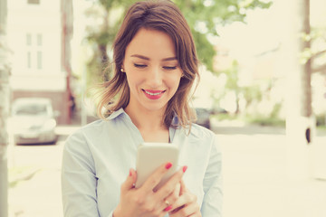 City happy young woman using mobile phone