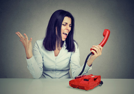 Angry young woman screaming on the phone