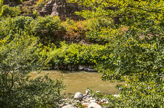 Current Derbent River from the mountains with muddy water and stones,&nbsp;among the trees of Armenia