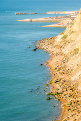 From Ecclesbourne Glen across blue sea English Channel site of proposed marina development to Hastings' beach